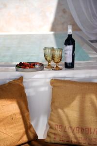 a bottle of wine and two glasses on a table at Arya Nobile Dimora in Carovigno