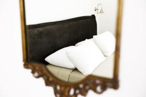 a mirror reflecting a couch with pillows on it at Arya Nobile Dimora in Carovigno