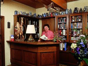 a woman sitting at a counter in a library at Pension Waldesruh in Welschneudorf