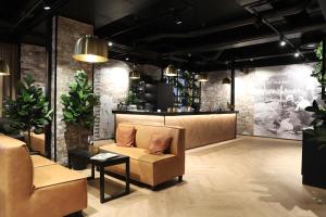 a lobby with a couch and a counter with plants at Original Sokos Hotel Rikala Salo in Salo