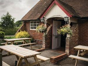 two wooden picnic tables in front of a brick building at The Walhampton Arms in Lymington