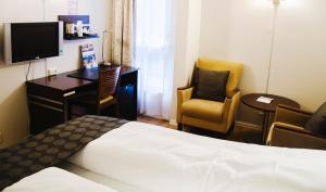 Una habitación de hotel con una cama, un escritorio y una silla. en Havly Hotell, en Stavanger