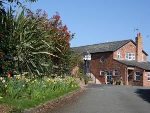 uma rua vazia em frente a uma casa de tijolos em Wall Hill Farm em Northwich