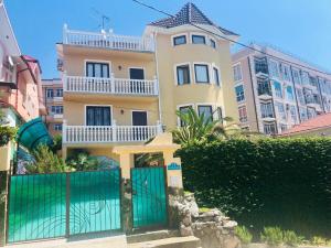 un edificio con una puerta verde delante de él en Golubaya Laguna Guest House, en Adler