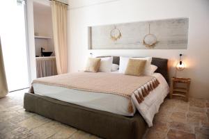 a bedroom with a large bed with white sheets and pillows at Arya Nobile Dimora in Carovigno