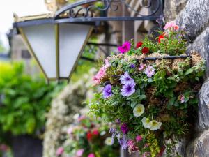 een mand met bloemen aan een stenen muur bij Wellington Inn in Harrogate