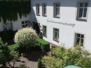 a white building with a sign on the side of it at Zum Weserdampfschiff in Bad Karlshafen