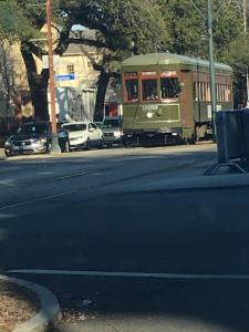 a trolley car driving down a city street with cars at WG Creole House 1850 in New Orleans