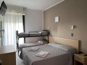 a bedroom with two beds with towels on them at Hotel Rex in Lido di Savio +48 photos