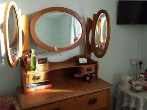 バースにあるWhite Guest Houseの鏡2つ付きの木製ドレッサー