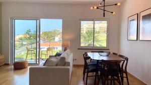 a living room with a couch and a table at Madeira Mero Apartment in Caniço