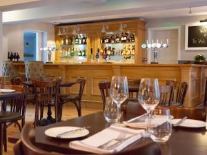 un restaurante con mesas y sillas y un bar en The White Horse Inn, en Pulborough