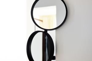a mirror with a black frame on a wall at Arya Nobile Dimora in Carovigno