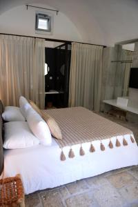 a bed with pillows on it in a room at Arya Nobile Dimora in Carovigno