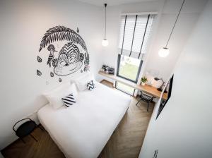 拉廊Blu Monkey Hub & Hotel Ranong的一间带床和书桌的白色卧室 更多37张照片
