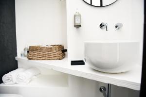 a bathroom with a sink and a basket on a shelf at Arya Nobile Dimora in Carovigno