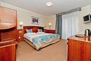 ブワディスワボボにあるWilla Domaroのベッドとデスクが備わるホテルルームです。