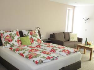 a couch with red and white pillows in a living room at Landgasthof Winzerscheune in Valwig