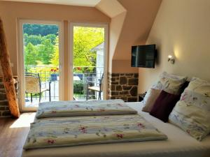 1 Schlafzimmer mit 2 Betten und einem großen Fenster in der Unterkunft Landgasthof Winzerscheune in Valwig