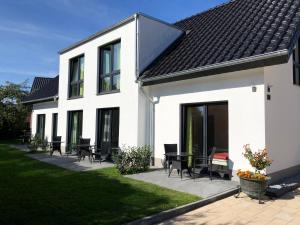 een wit huis met tafels en stoelen in de tuin bij Gästehaus Witteborg in Paderborn