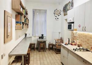 a kitchen with white cabinets and a table in it at Etno Hostel in Lviv
