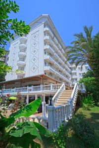 Un grand bâtiment blanc avec des escaliers se trouve juste devant. dans l'établissement Ramira Beach Hotel - All Inclusive, à Avsallar