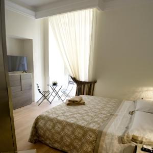 a bedroom with a bed and a dresser and a window at fafgrandsuitenapoli in Naples
