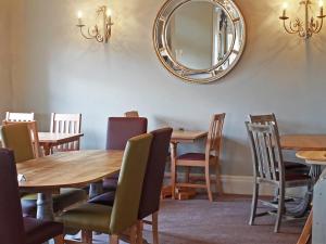 een eetkamer met houten tafels en stoelen en een spiegel bij Woodberry Inn in Bridgnorth