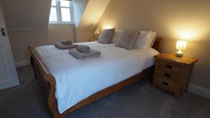 a bedroom with a large bed with towels on it at Woodlands View in Halesworth