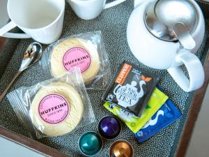 a tray with cookies and a cup of coffee and tea at Woolmarket House in Chipping Campden