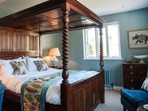 a bedroom with a canopy bed and a window at Woolmarket House in Chipping Campden