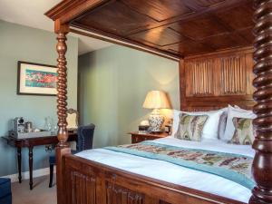a bedroom with a wooden canopy bed and a desk at Woolmarket House in Chipping Campden +29 photos
