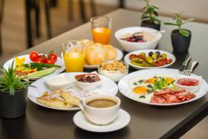 a table topped with plates of breakfast foods and drinks at Dangė Hotel in Klaipėda