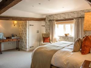 a bedroom with a large bed and a window at Woolmarket House in Chipping Campden