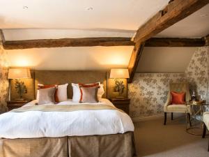 a bedroom with a large bed and two chairs at Woolmarket House in Chipping Campden