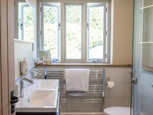 a bathroom with two sinks and two windows at Woolmarket House in Chipping Campden