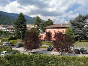 a pink building with cars parked in a parking lot at Apartment Annive in Levico Terme