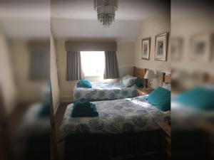 a bedroom with two beds and a window at Ye Olde Robin Hood Inn in Ironbridge