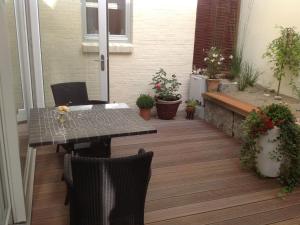 a patio with a table and chairs and plants at Zeit in Eckernförde in Eckernförde