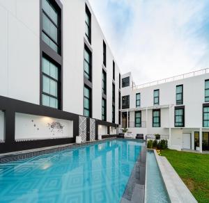 拉廊Blu Monkey Hub & Hotel Ranong的建筑物前的游泳池