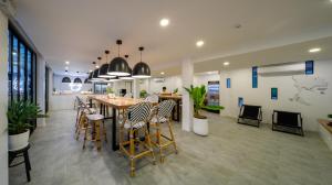 拉廊Blu Monkey Hub & Hotel Ranong的带桌椅的餐厅和厨房