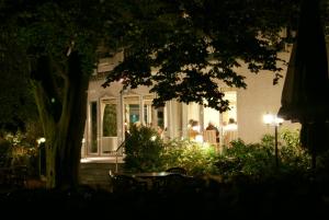 eine Gruppe von Menschen, die vor einem Haus sitzen in der Unterkunft Zum Jägerkrug in Bad Rothenfelde