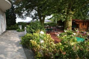 a patio with a bunch of plants and a tree at Zum Jägerkrug in Bad Rothenfelde