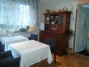 uma sala de jantar com uma mesa e um armário de madeira em Pension Zur Kirchsee em Insel Poel