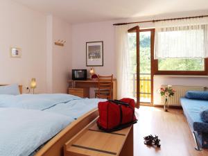 Veldenz的住宿－Pension zur Mühle，一间卧室设有两张床,桌子上有一个红色的袋子