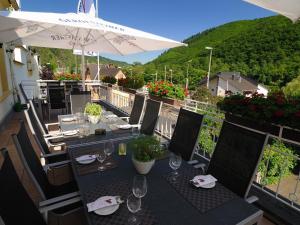 una mesa con copas de vino y una sombrilla en el balcón en Hotel Zur Post, en Klotten