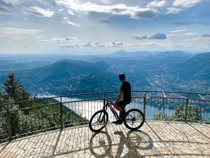 Un uomo che va in bicicletta sulla cima di una montagna di Bellavista Boutique Hotel a Brunate