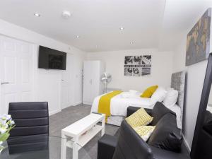 a white bedroom with a bed and a couch at Berkley Studio in Leeds