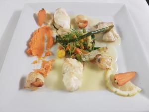 un plato de comida con camarones y verduras. en Hôtel La Champagne Ardenne Cabourg en Cabourg