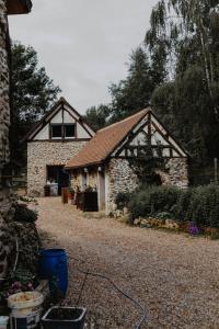 une maison en pierre avec une allée en face de celle-ci dans l'établissement Le Clos du Buisson, à Saint-Julien-de-la-Liègue